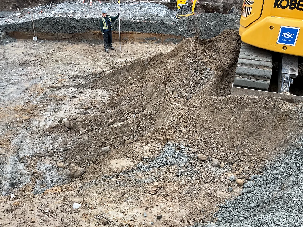 NSC excavator and grade checker in the bulk excavation for the building footprint
