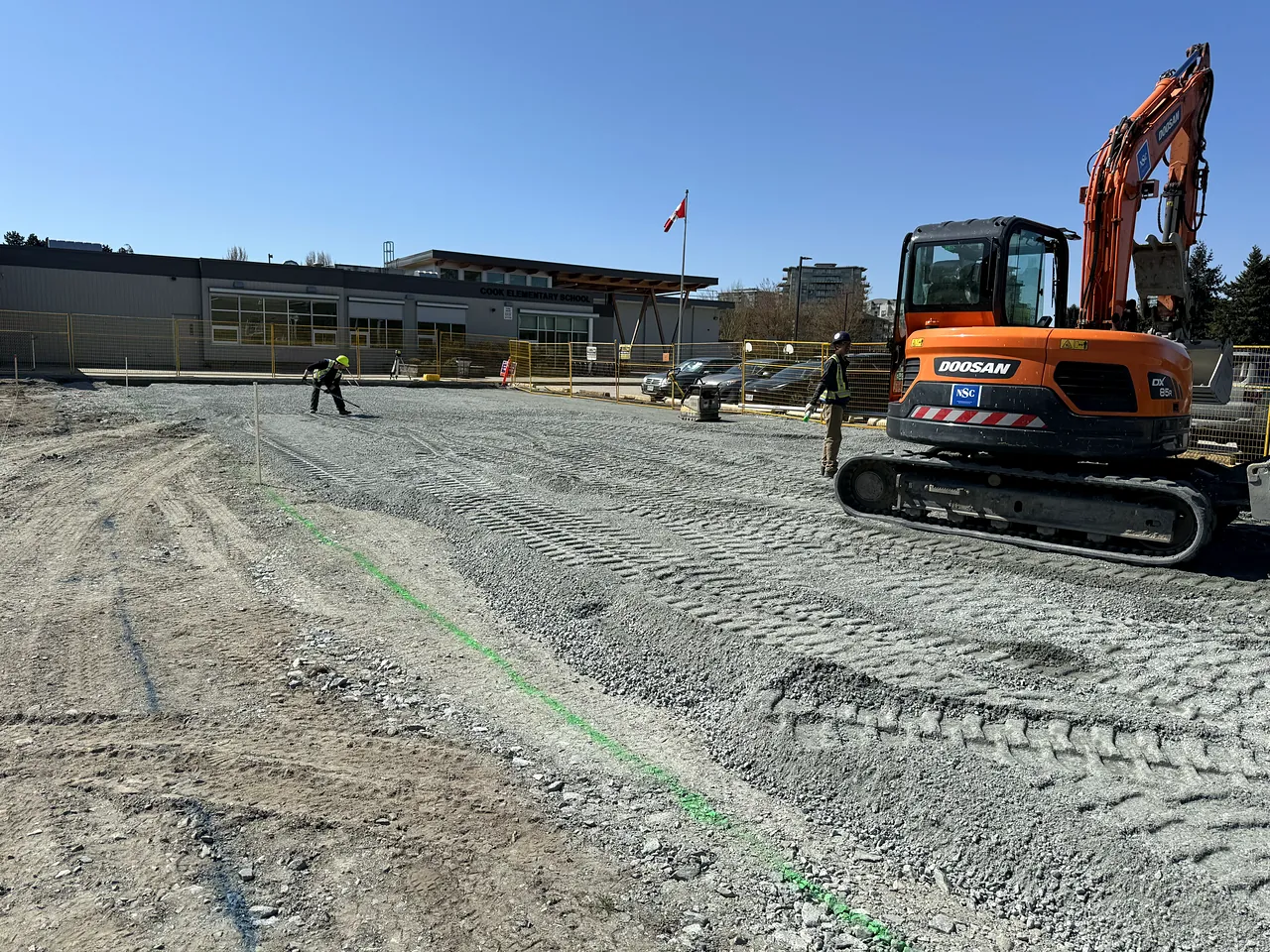 NSC excavator and crew member grading the granular base for the modular addition