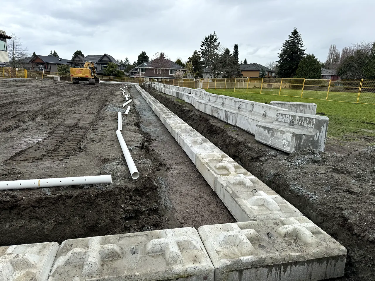 Lock-block retaining wall and perforated drain pipe installed around the site
