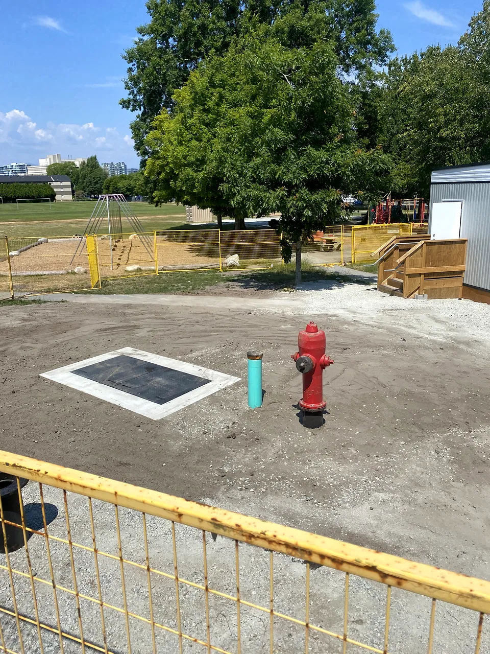 Completed valve chamber lid and hydrant beside the new portables at Brighouse Elementary