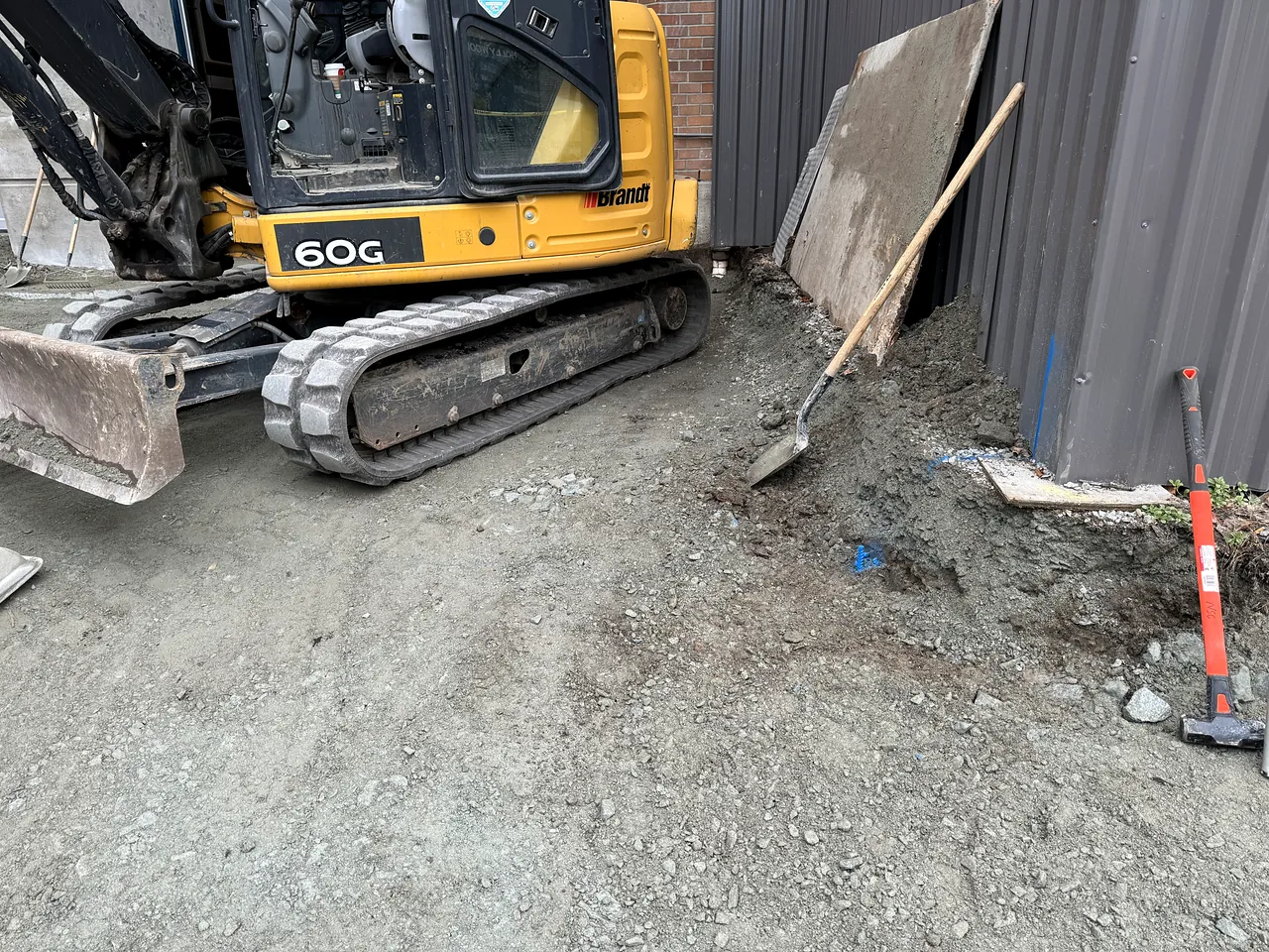 Compact excavator working beside the fire hall