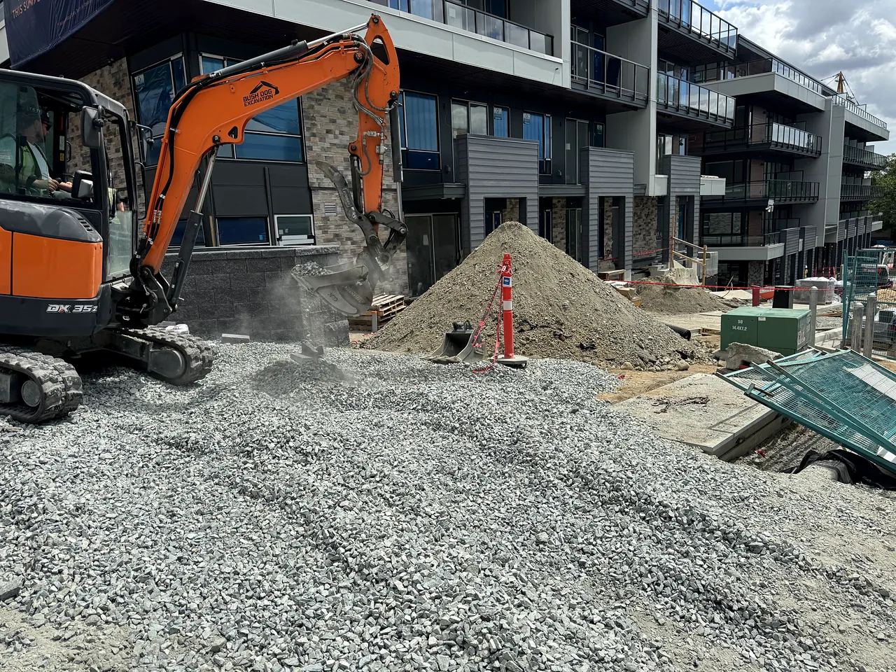 Mini excavator placing gravel at the Florin townhouse site