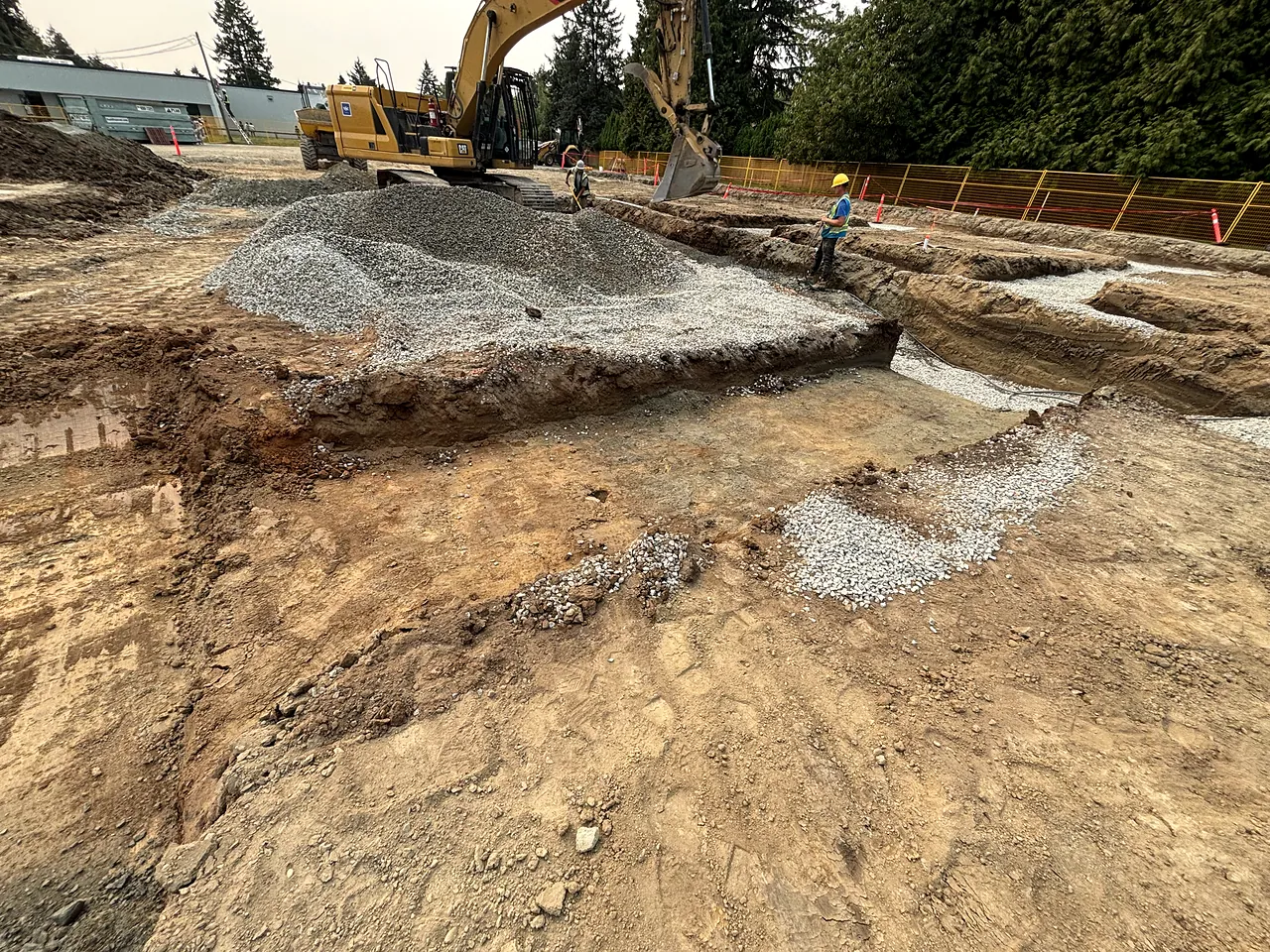 NSC CAT excavator and crew excavating footings at George Greenaway Elementary