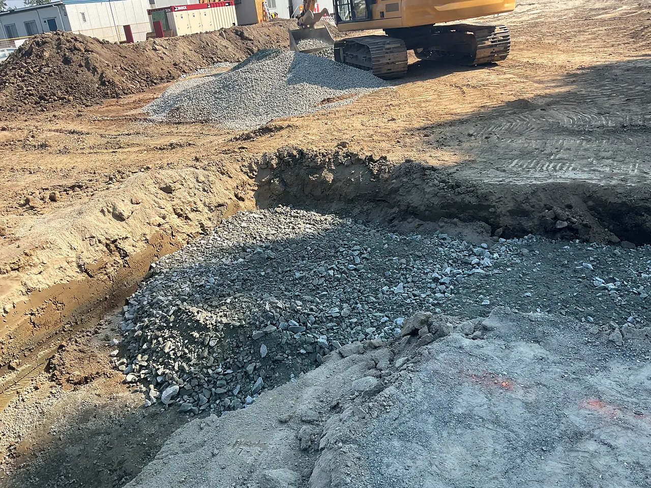 Excavated building pad with drain rock placement