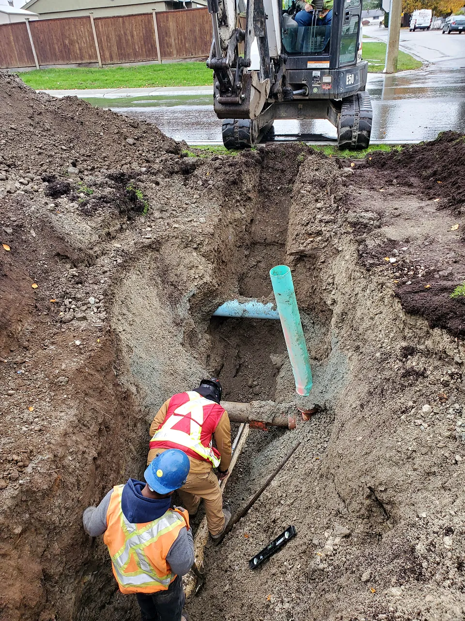 Crew connecting a new PVC service lateral in the trench