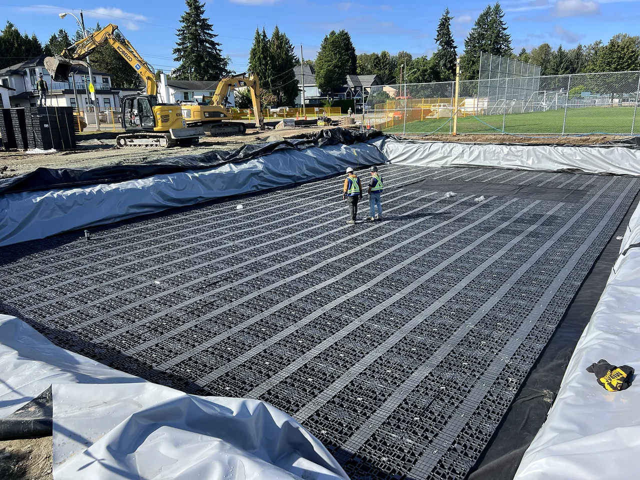 Stormwater detention tank under construction at Guildford Park Secondary, with NSC excavators and crew