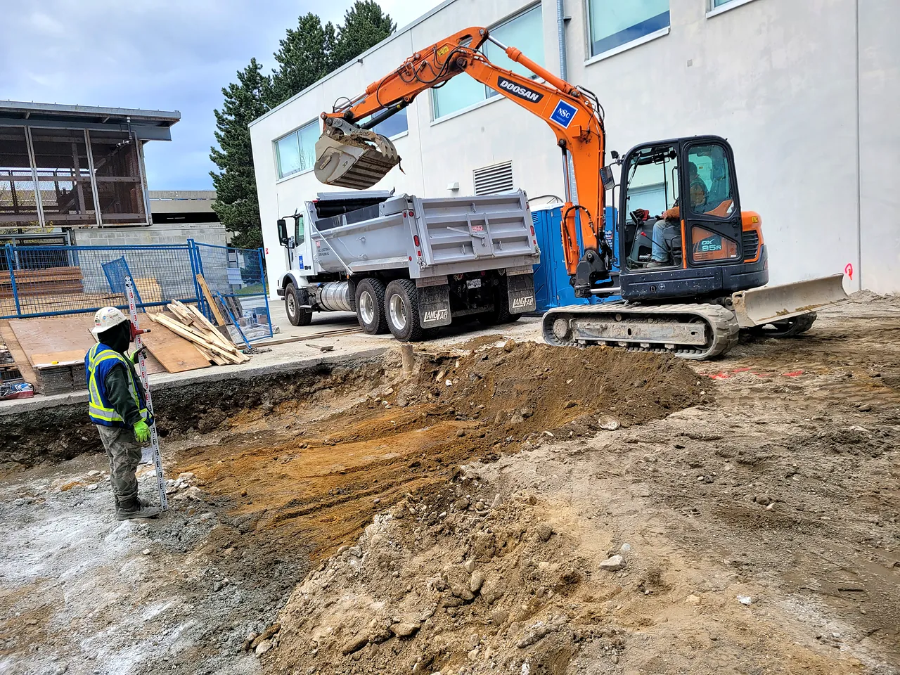 Bulk excavation with excavator, dump truck and grade checker