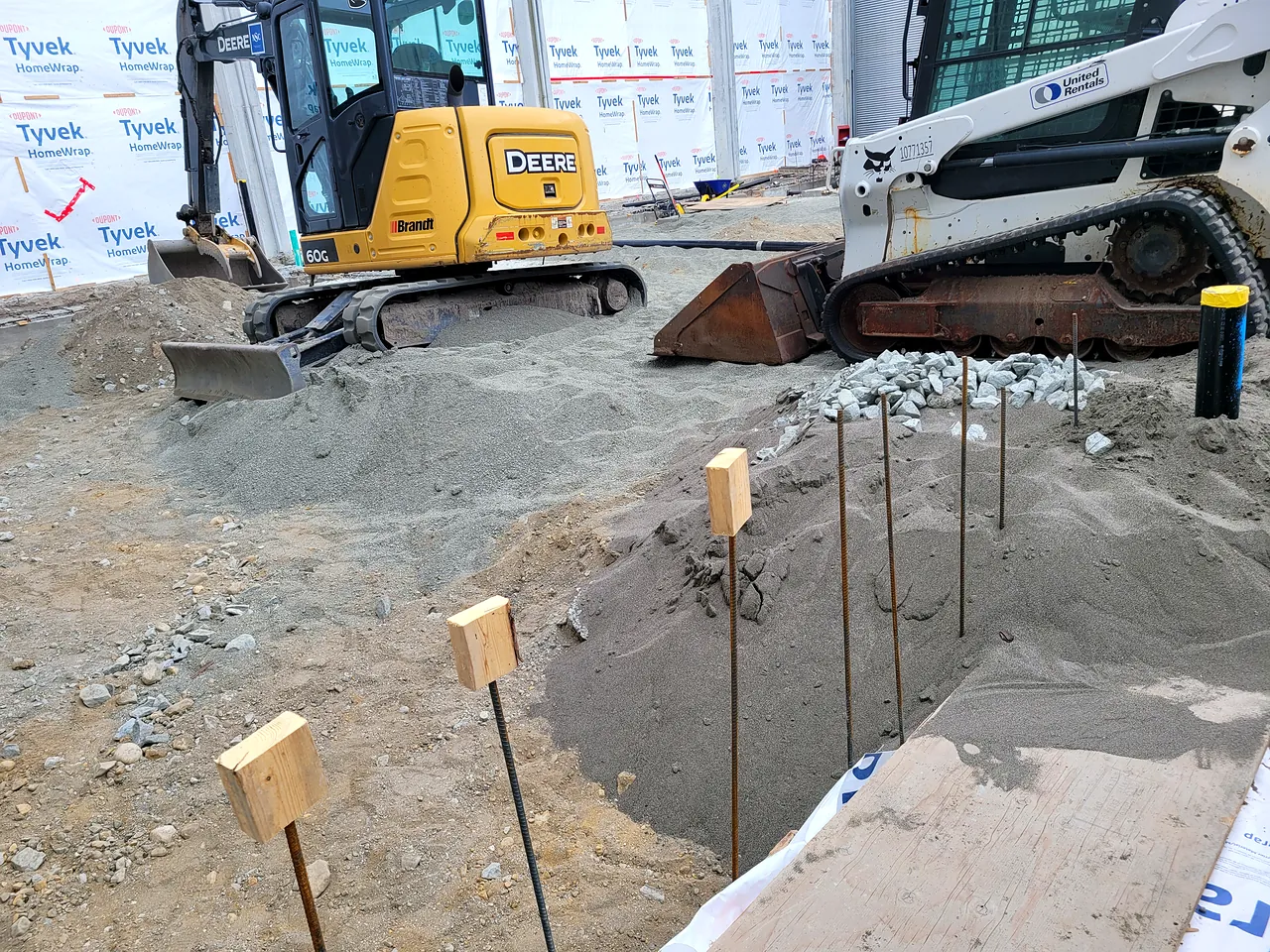 Excavator and track loader on the prepared subgrade